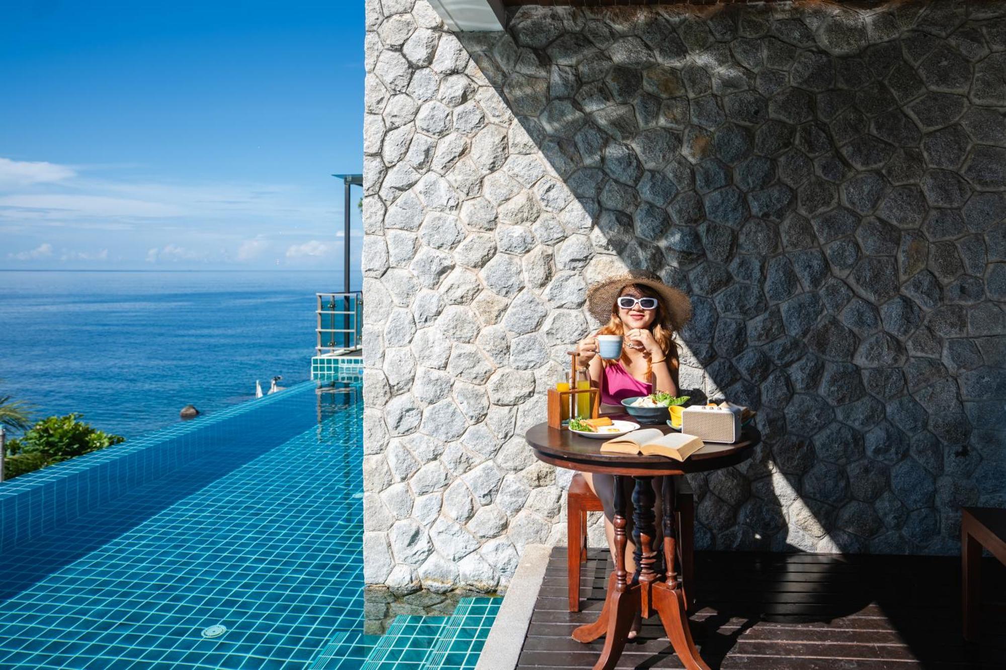 Zenmaya Oceanfront Phuket, Trademark Collection By Wyndham Patong Kültér fotó A woman enjoying a morning coffee at the poolside of the resort
